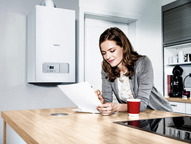 woman leaning on kitchen counter to read letter