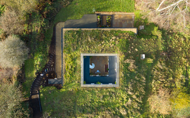 Overhead view of the turf covered self-heating house set into a bank of earth