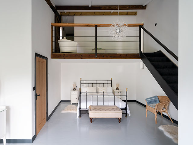 Metal framed bed in master bedroom with spacious area and steps leading into it