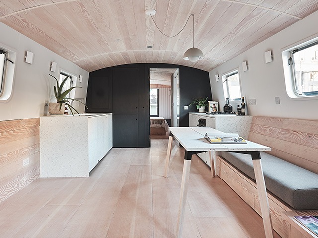 The wood clad kitchen and dining area in the floating off-grid home 