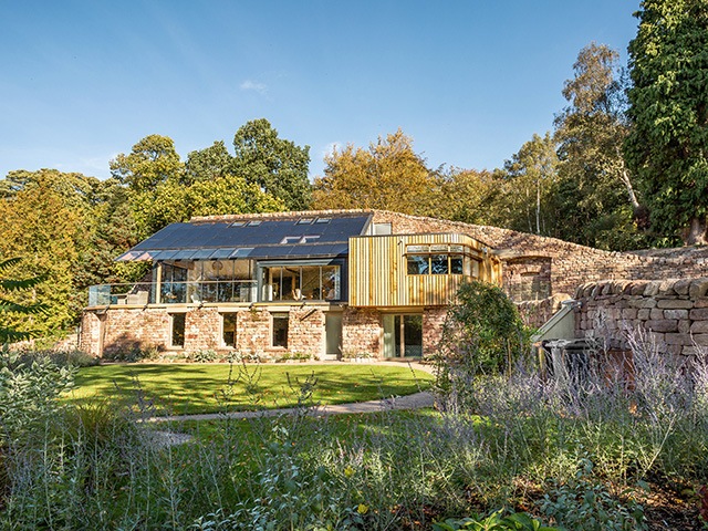 The stone and timber exterior of the off-grid house in a former quarry