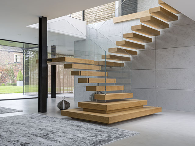 A cantilevered staircase with oak treads and glass balustrade.