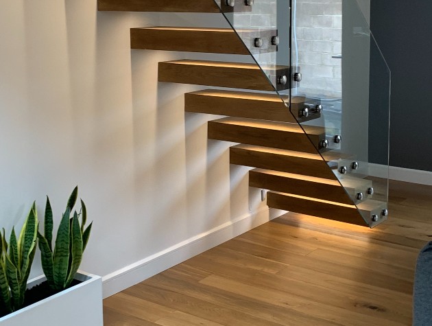 Floating staircase with ambient lighting and a potted plant