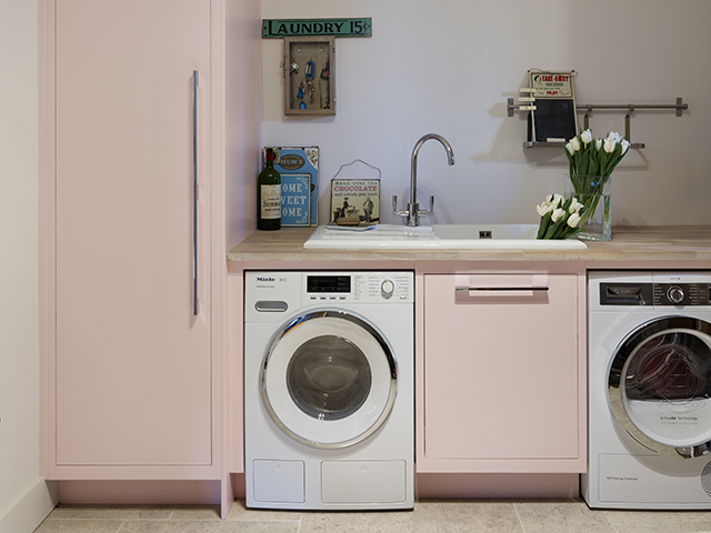 Harvey Jones Laundry Room with pink cupboard space, washing machine and tumble dryer