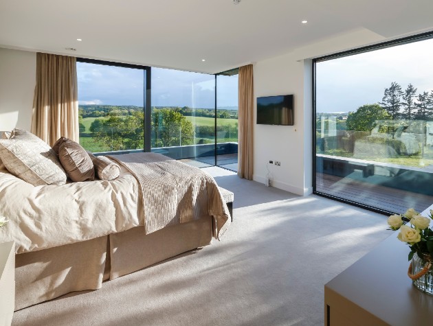 bedroom with full length windows and sliding doors leading to balcony