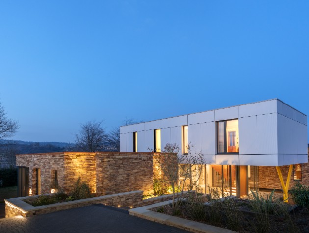 contemporary home with stone clad ground floor and white cantilevered first floor