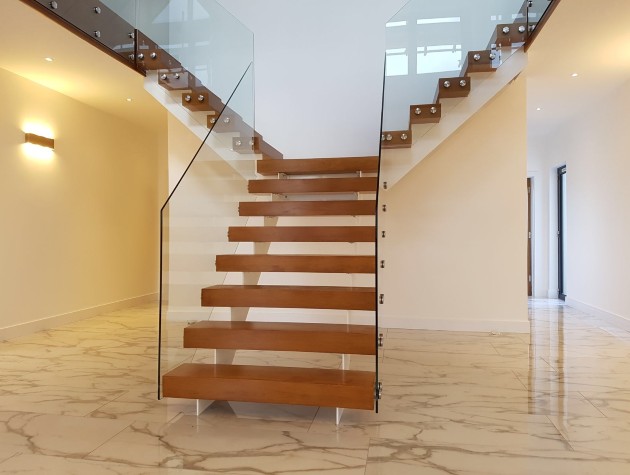 glass bordered staircase in a hallways with marble flooring