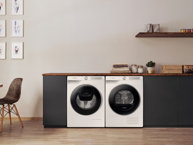 interior of kitchen with black units wooden worktop and white Samsung washing machine