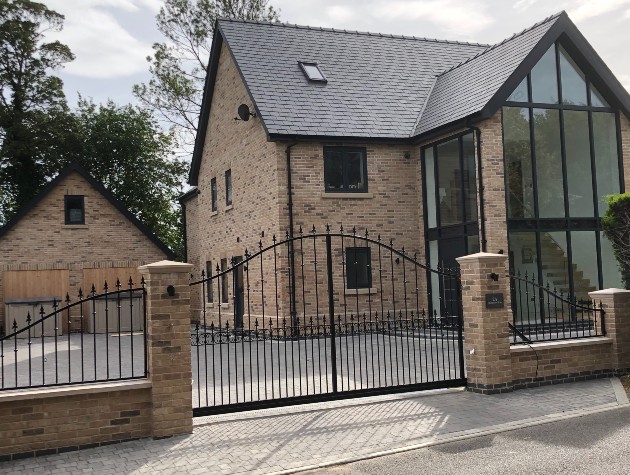 iron gates in front of modern house with full height window