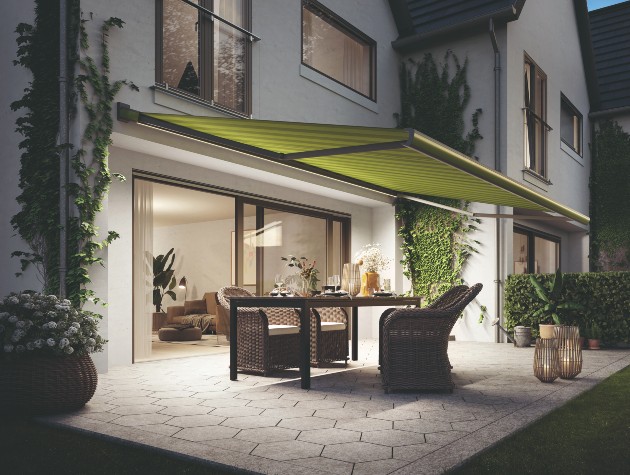 rear of home with awning and rattan patio furniture