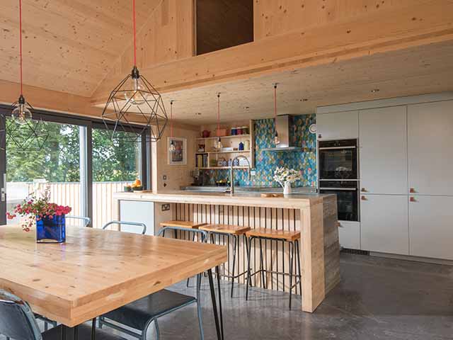 Kitchen area with bar and table. The breakfast bar is built with timber offcuts