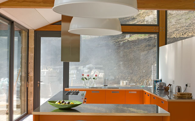 U-shaped bright orange kitchen in the Grand Designs paper mill