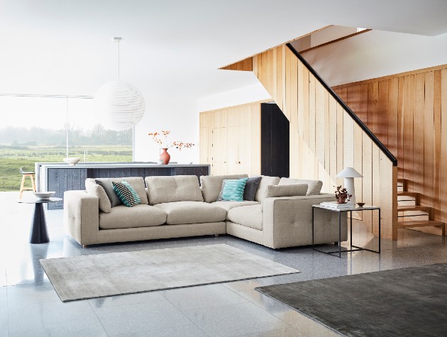 beige modular sofa with arm detailing and bordered cushions in large open plan space