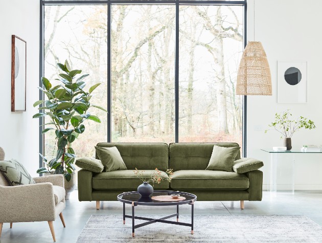 green sofa with squared arms and quilting details in white minimalist room