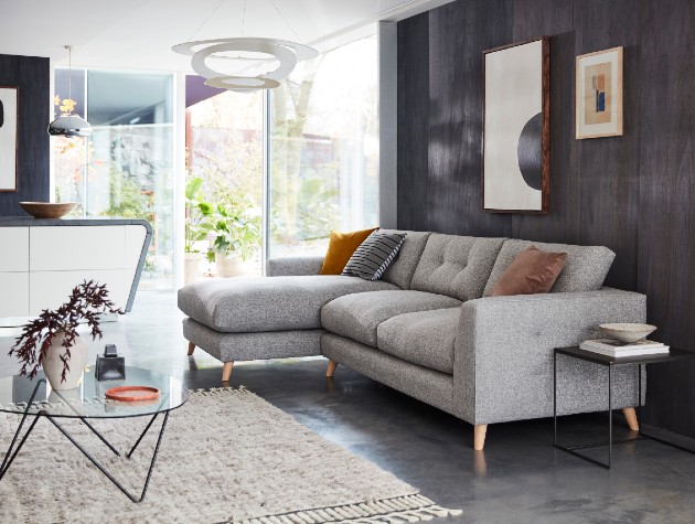 grey contemporary sofa with tailored arm panel and wooden feet in monochrome living room with modern art prints