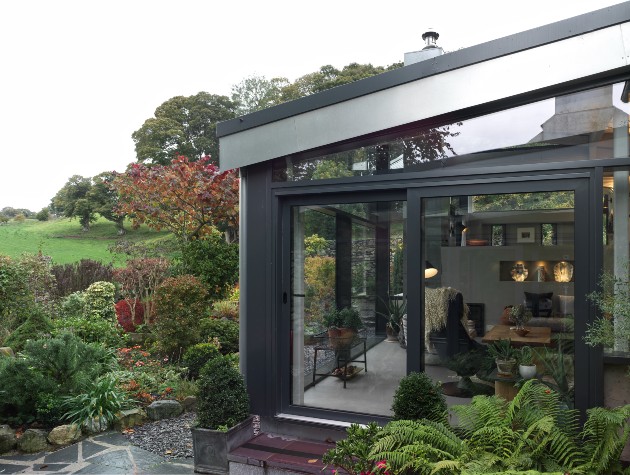 side view of Shüco sliding glass doors linking living room and garden