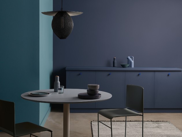 small round table with chairs in kitchen area painted in shades of blue