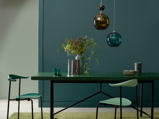 table and chairs with pendant lights and plants in blue room