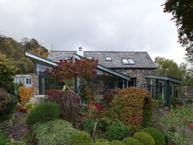 view of extension from garden showing Shüco sliding glass doors and pitched roofs