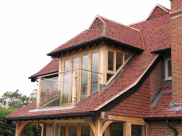  View of rich red clay roof tiles on a traditional pitched roof, showing the versatility of the roofing materials