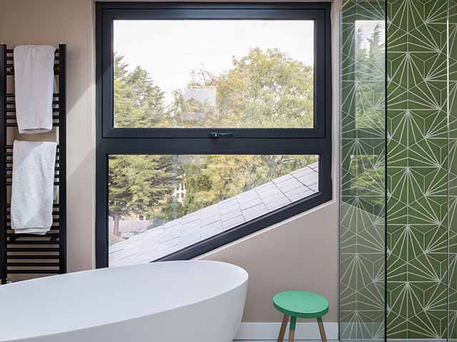 Loft bathroom with angular window following the roofline