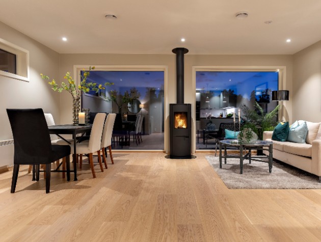 combined living and dining room with black woodburning stove and chimney