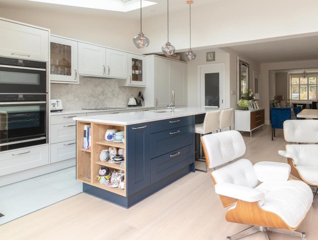 Masterclass Kitchens open plan kitchen diner with white peripheral cabinetry navy blue kitchen island incorporating open shelving