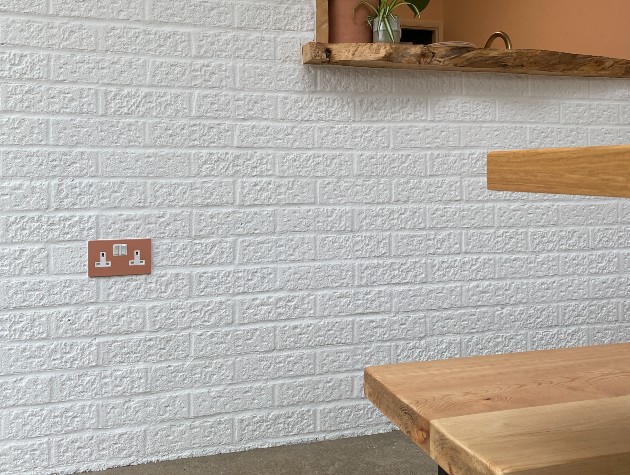 White brick wall with gold sockets and wooden counter top