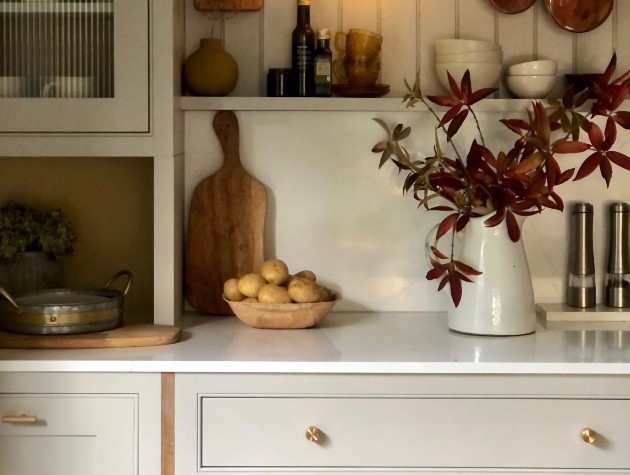 White kitchen counter with vase and autumnal plant