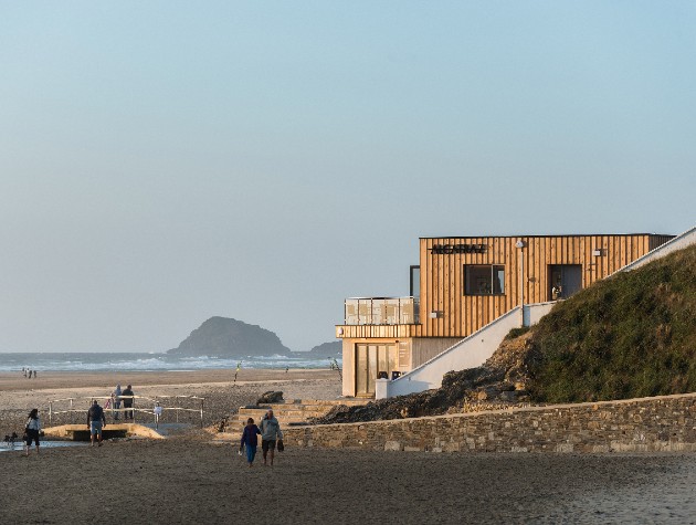 beach with people walking sea and modern building