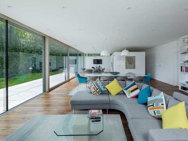 large open plan room with sofa shelves tables and sliding glass doors