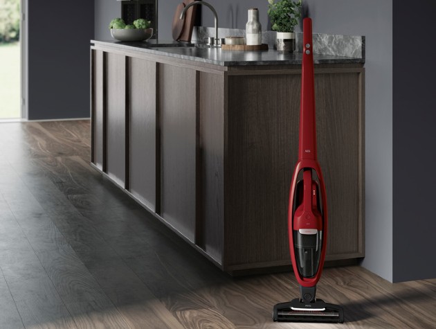 red cordless vacuum cleaner stood upright in kitchen