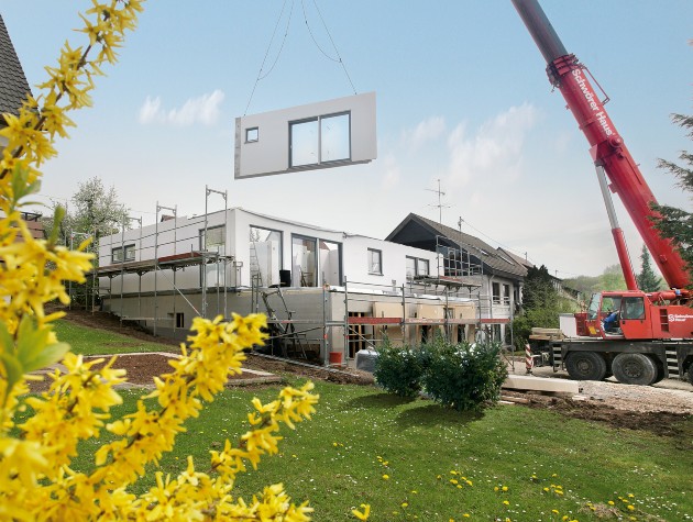 crane lowering section of a prefab house into place