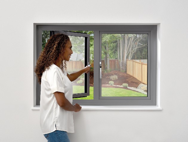 woman opening grey framed window to outside