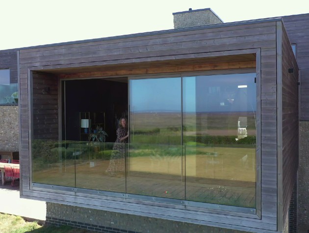 woman opening sliding door of modern home