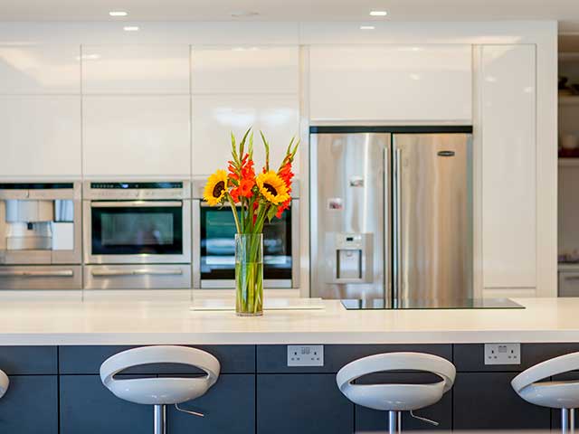 The breakfast bar with navy cupboards and white counter 