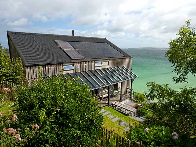 Roof of beachfront house surrounded by trees