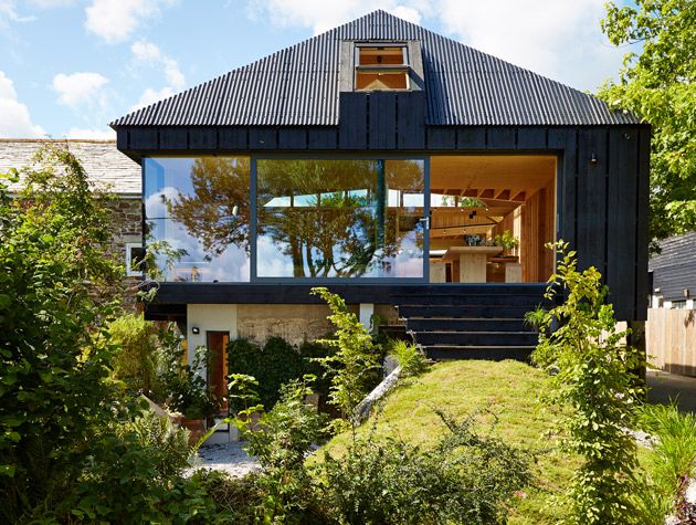 Black clad treehouse timber interior full length glazing green hill