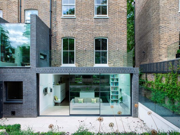 a grey brick extension with floor-to-ceiling glass on a red brick Edwardian terraced house