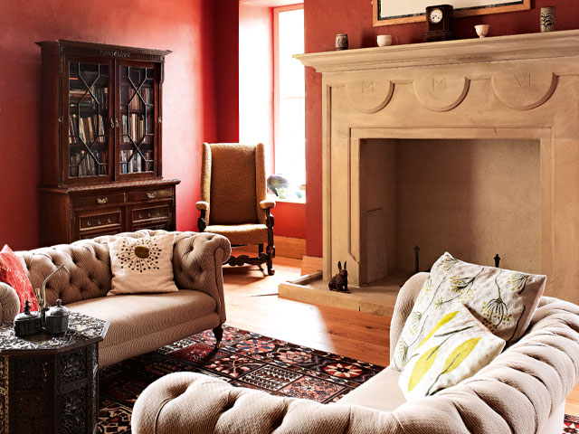 Inside Peel castle, featured on Grand Designs, with original fireplace and burnt orange walls