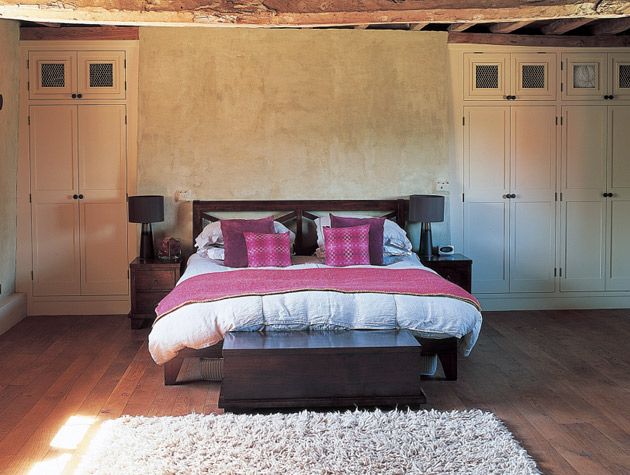 A bedroom with beamed ceilings in a 16th century Gloucestershire farmhouse