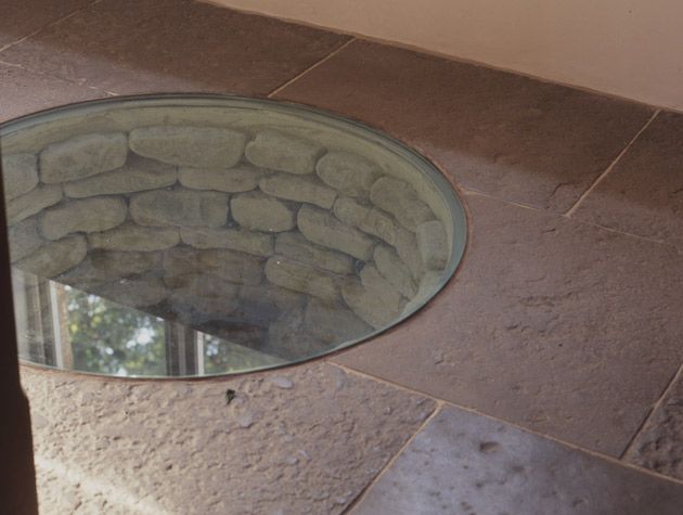 A glass lid covering an old well in a 16th century farmhouse kitchen