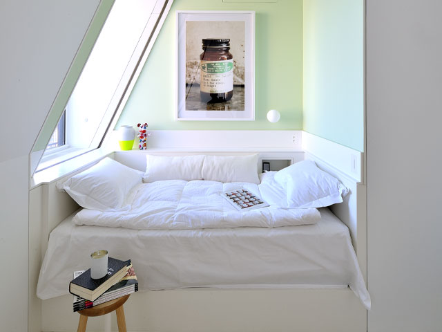 reading nook in an attic alcove with daybed and pale green walls