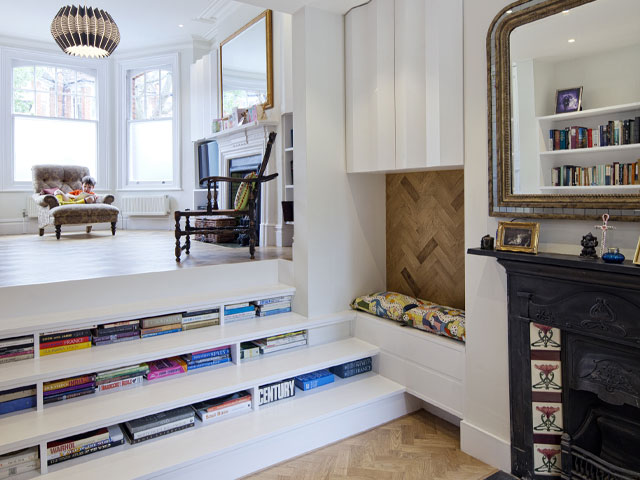 a bookshelf staircase in a London flat with split-level living areas