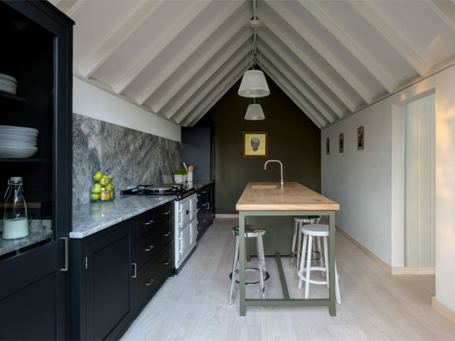 barn conversion kitchen in west sussex with timber beam ceiling and dark kitchen fittings