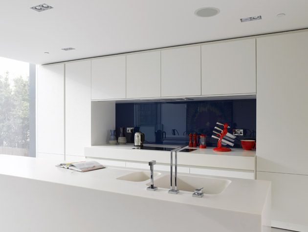 modern white handleless kitchen with indigo blue splashback
