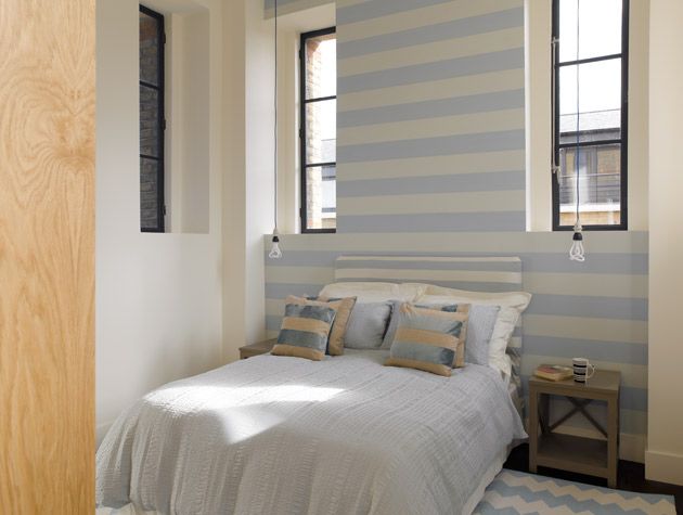 Bedroom with high ceilings and narrow windows inside the Grand Designs Water Tower 