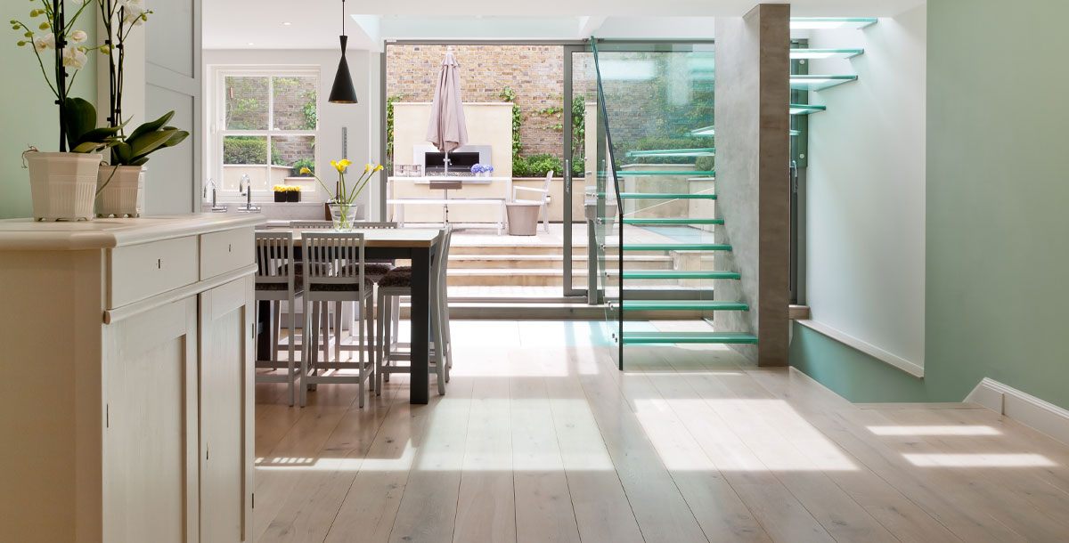 A basement kitchen extension in Kensington with glass staircase and courtyard garden