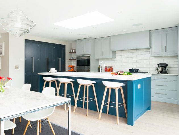 modern kitchen with large island, dining table and blue cabinets
