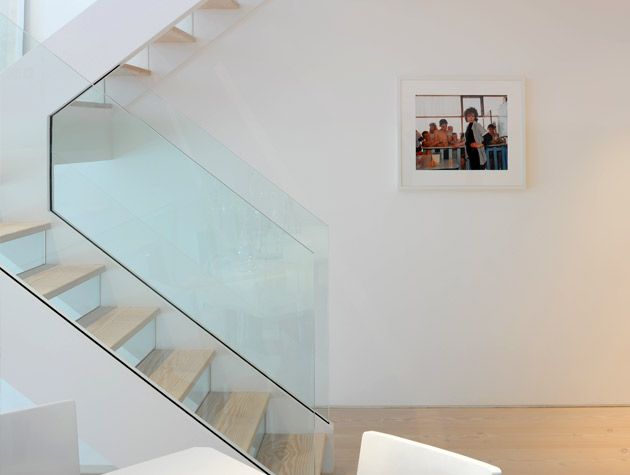 White contemporary staircase with glass balustrades family photo with white frame